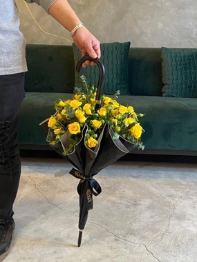 Black umbrella and yellow roses