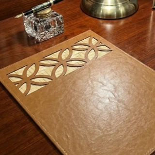 A luxurious plate base made from recycled leather, decorated with hand-woven wicker.