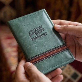 Luxury green passport cover made from recycled leather, decorated with hand-stitched green and red.