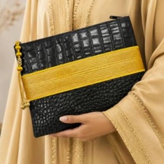 A luxurious bag in black leather and hand-stitched gold zari