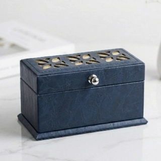 A small box containing an incense burner and oud, made of luxurious navy blue leather and decorated with silver zari.