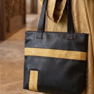 A luxurious handbag in the shape of the Kaaba, decorated with hand-crafted zari.